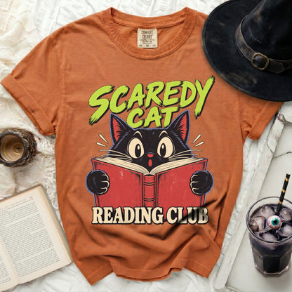 Orange t-shirt with black cat reading a book and "Scaredy Cat Reading Club" text.