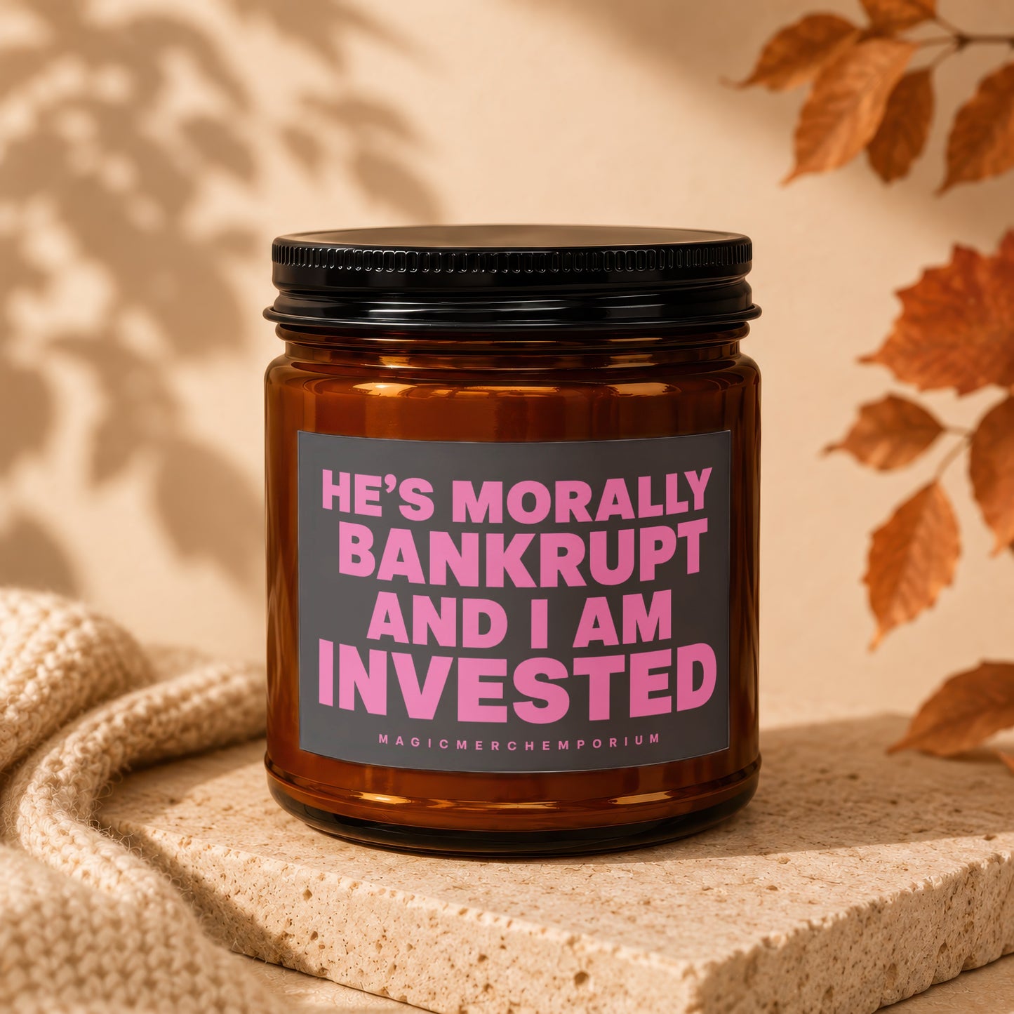 Brown glass candle with black lid, label reads "He's Morally Bankrupt and I Am Invested".