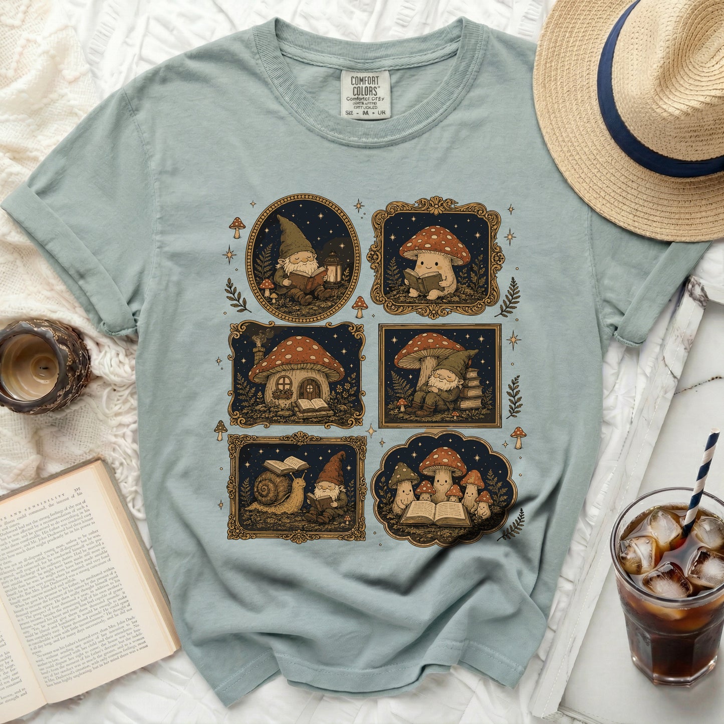 T-shirt with comfort colors tag and a graphic of gnomes, mushrooms, and a snail reading books.