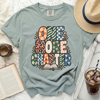 Green t-shirt with "ONE MORE CHAPTER" text and an open book.