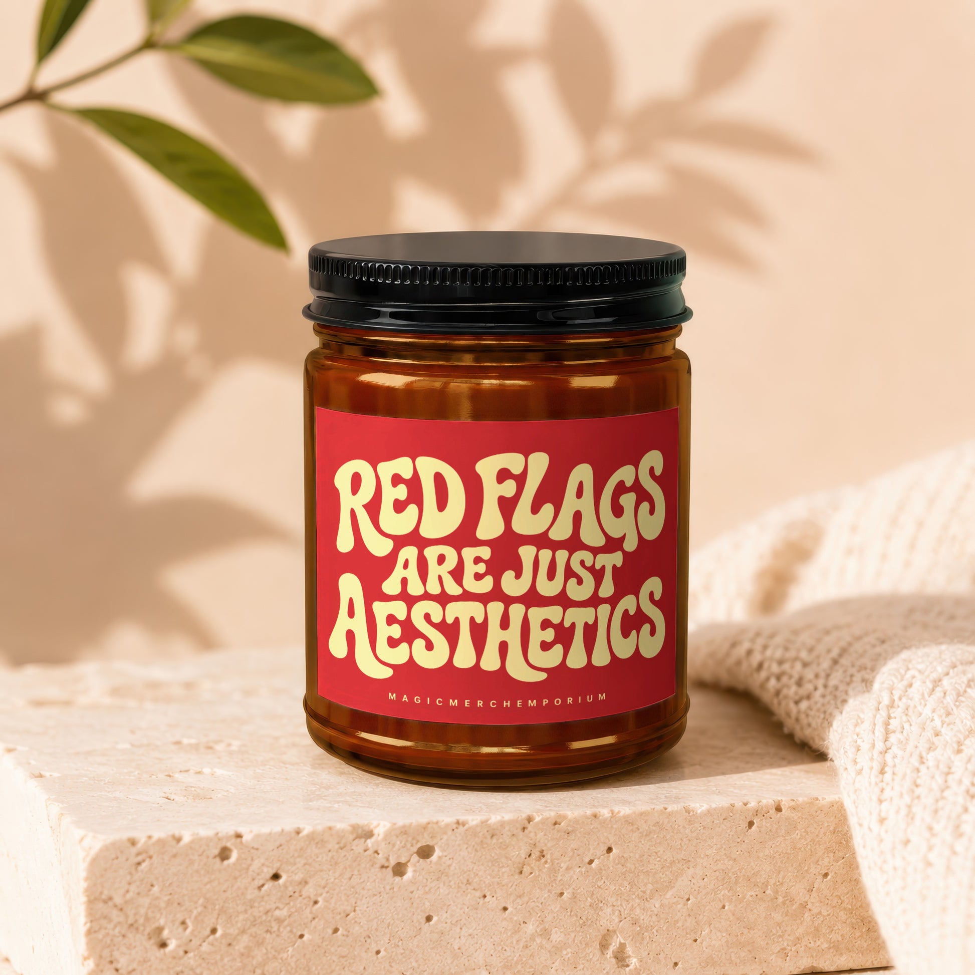 Amber jar candle with red label reading "Red Flags Are Just Aesthetics".