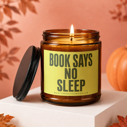 Amber glass candle with lit wick and black lid. Label reads "BOOK SAYS NO SLEEP".