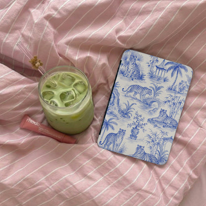 Green matcha drink next to a cosmetic tube and a device with blue tiger pattern.