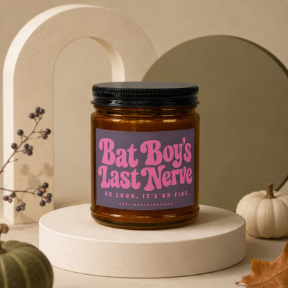 Amber jar candle with purple label reading "Bat Boy's Last Nerve, OH LOOK, IT'S ON FIRE".