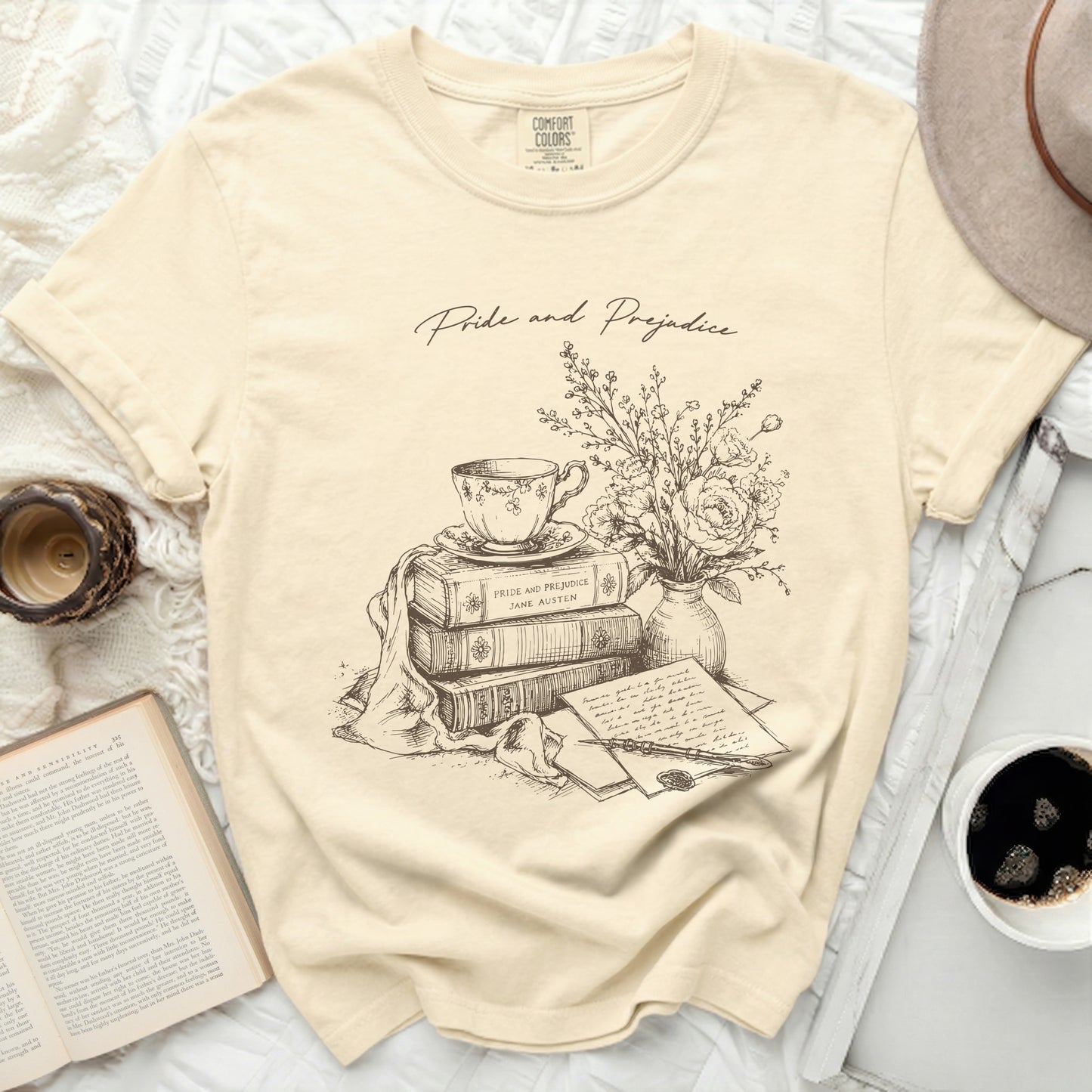 Cream t-shirt with "Pride and Prejudice" and sketch of teacup, books, and flowers.