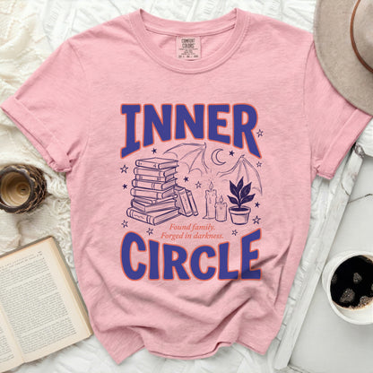 Pink t-shirt with "INNER CIRCLE" and dark illustrations of books, bats, and candles.