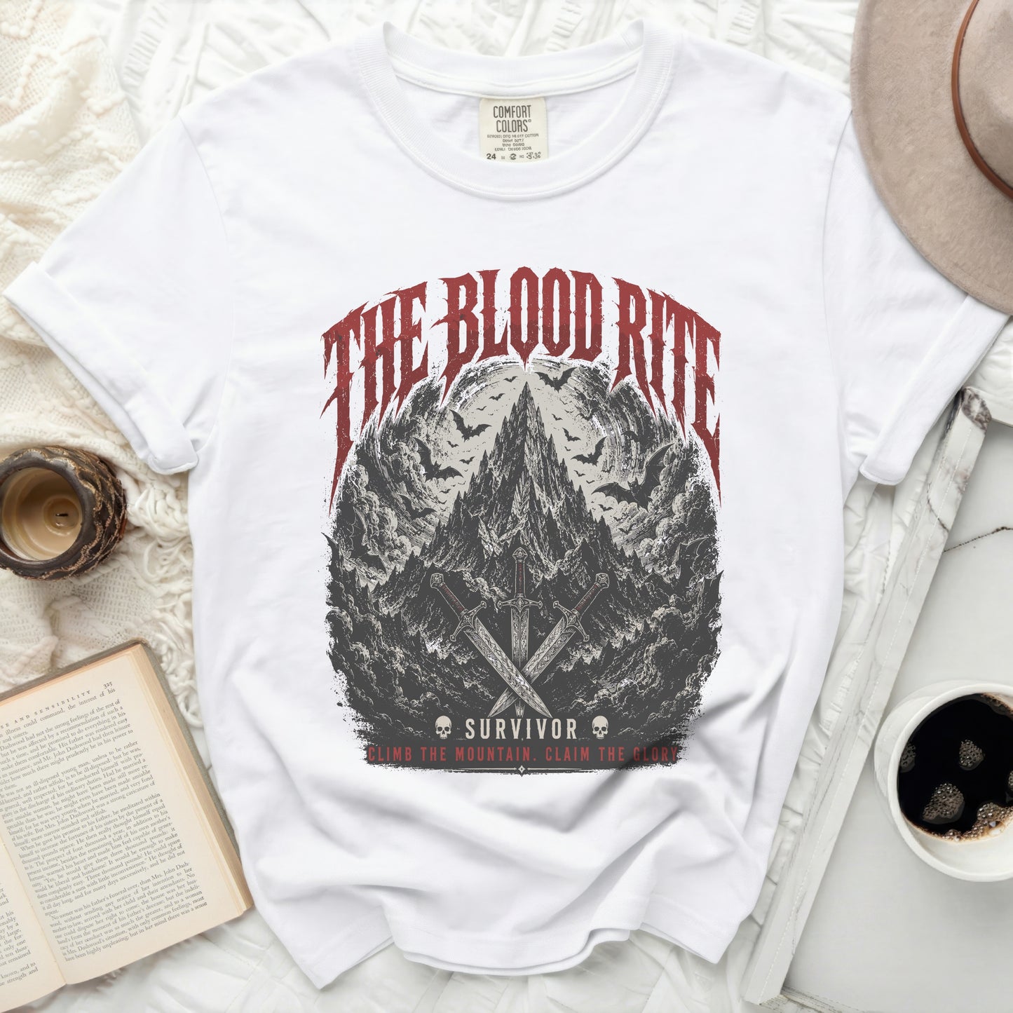 White t-shirt with "The Blood Rite Survivor" graphic and swords.