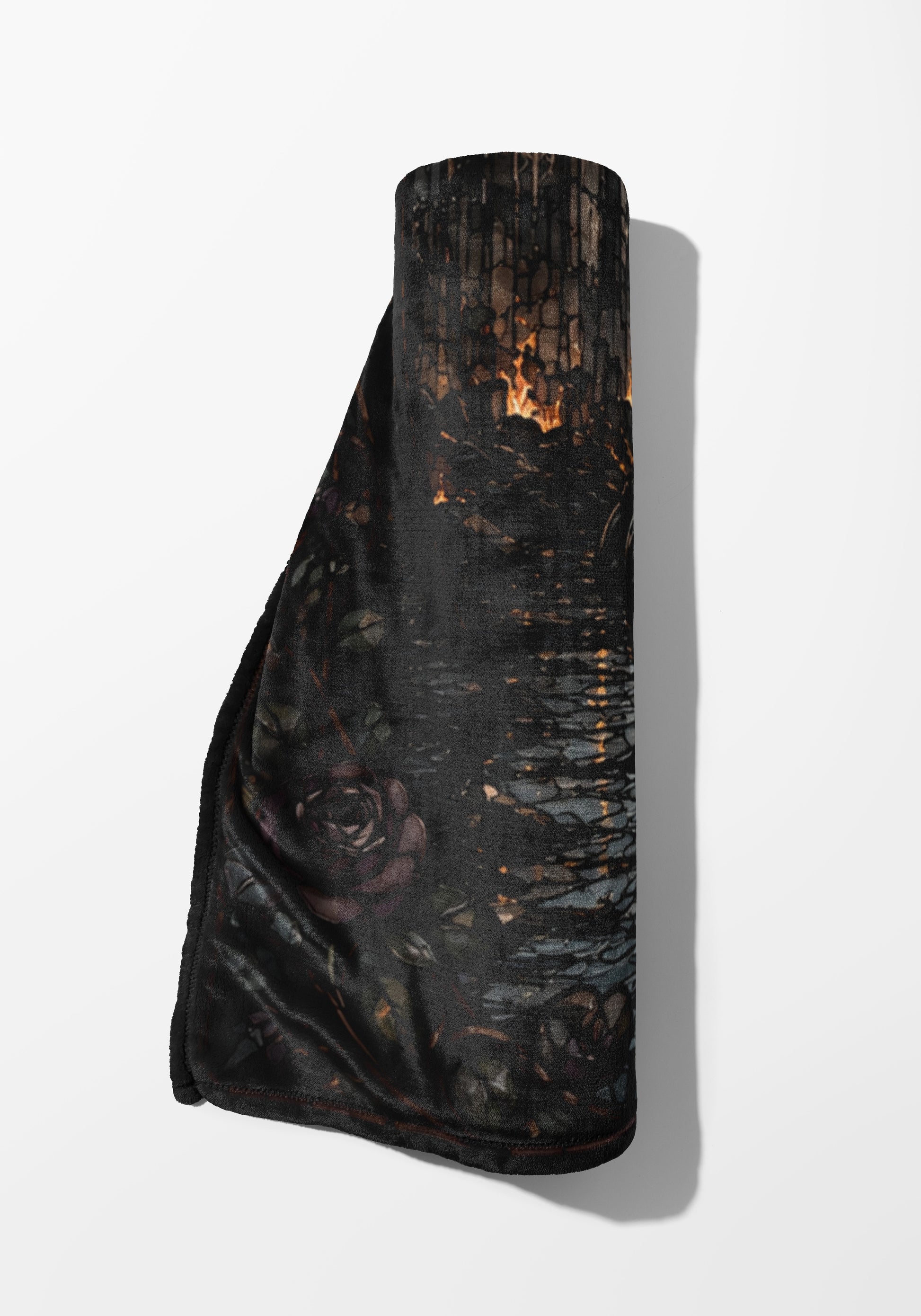 Rolled dark blanket with a rose and burning wood pattern.