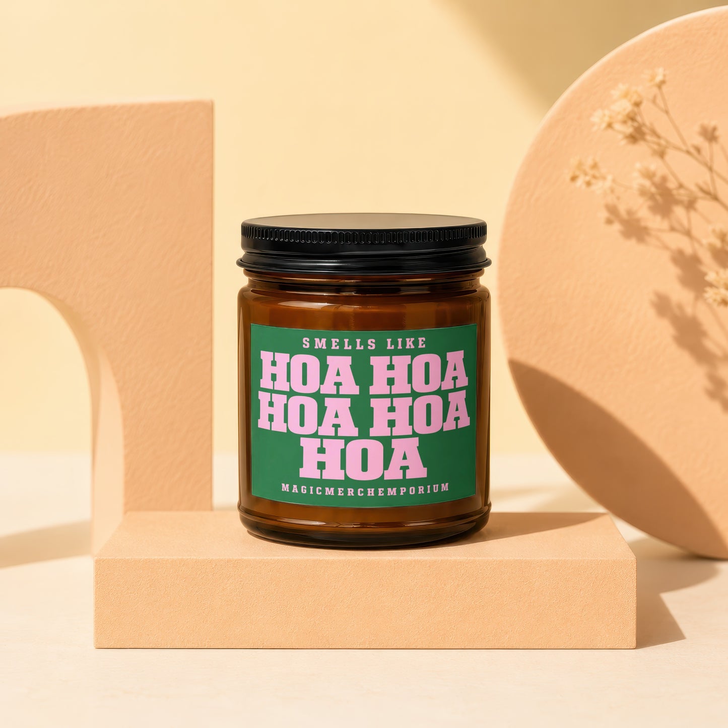 Amber candle with green label saying "Smells like Hoa Hoa Hoa Hoa" and "MagicMerchEmporium".