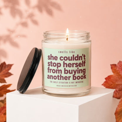 Candle with text "smells like she couldn't stop herself from buying another book".