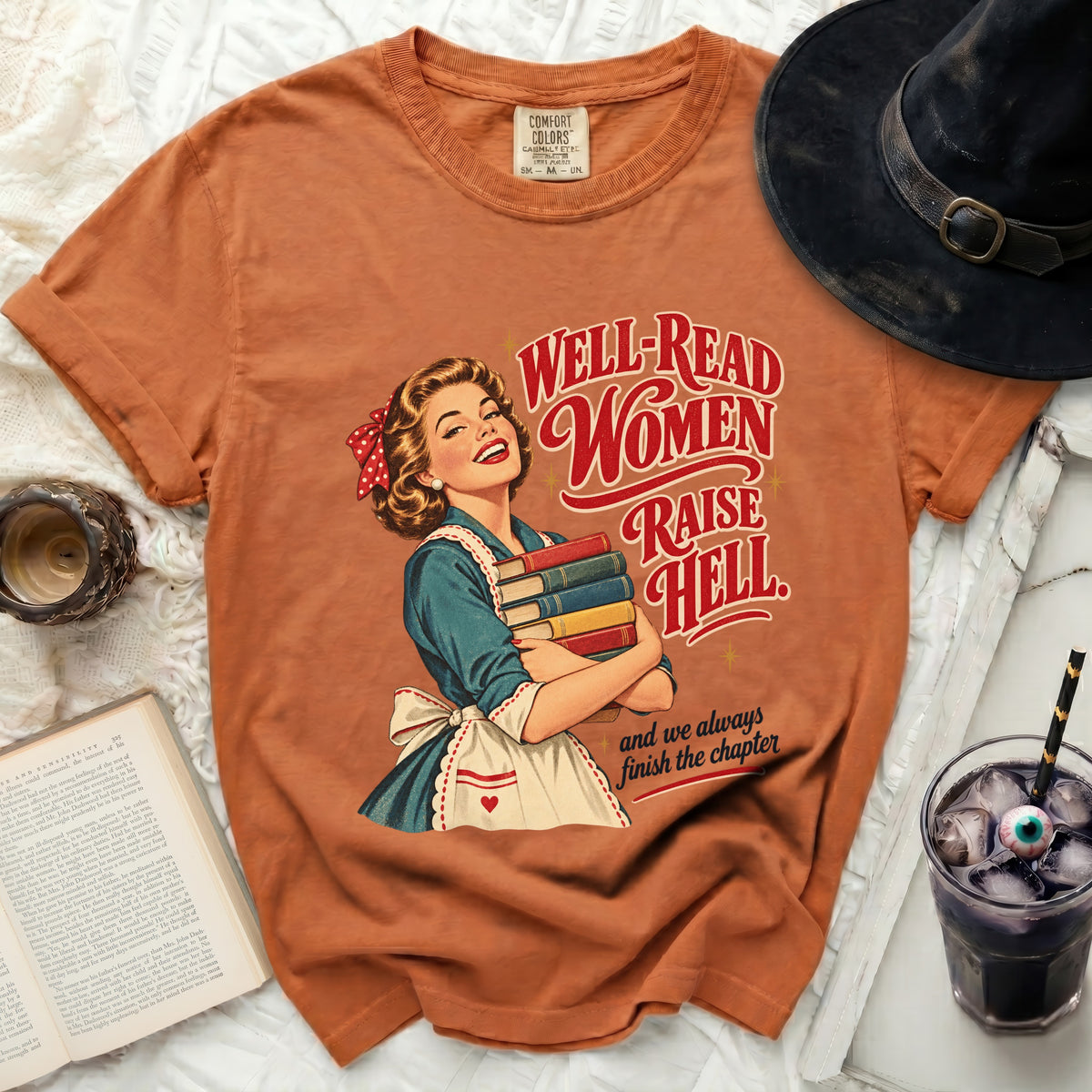 Orange t-shirt with "Well-Read Women Raise Hell" graphic and vintage woman holding books.