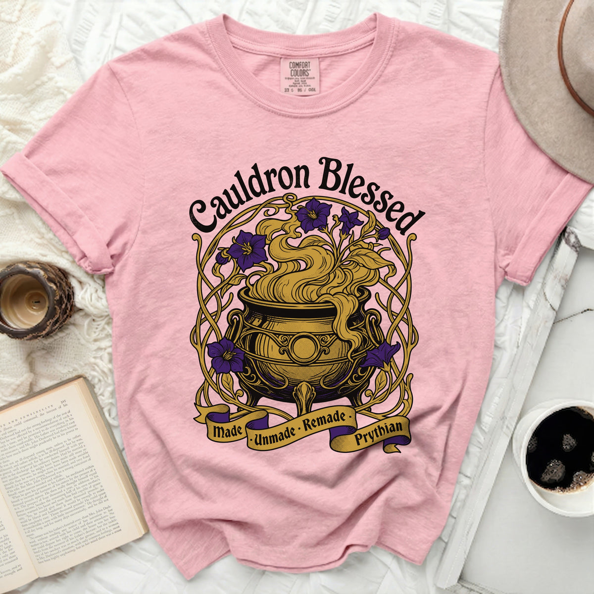 Pink shirt with "Cauldron Blessed" and a cauldron graphic.