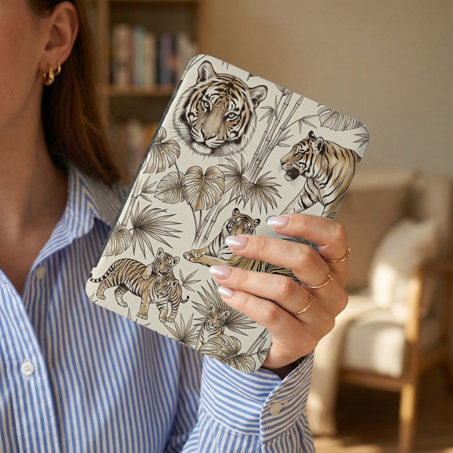Case with tiger and bamboo pattern, held by a woman wearing a striped shirt.