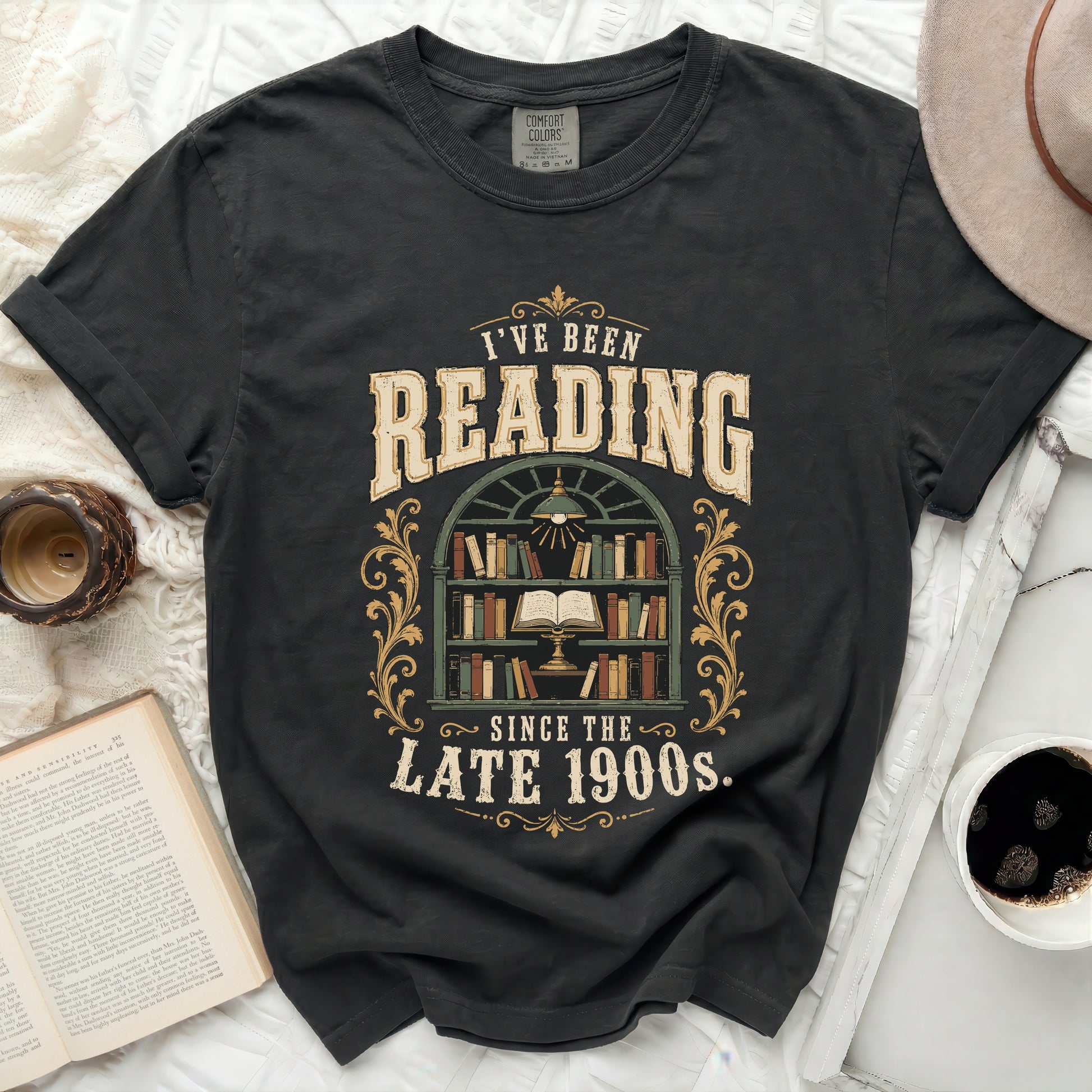 Graphic t-shirt with "I've Been Reading Since The Late 1900s" text and bookshelf.