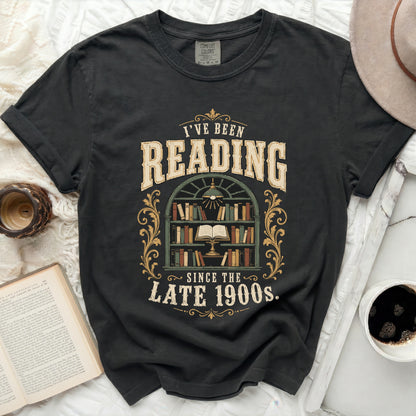 Graphic t-shirt with "I've Been Reading Since The Late 1900s" text and bookshelf.