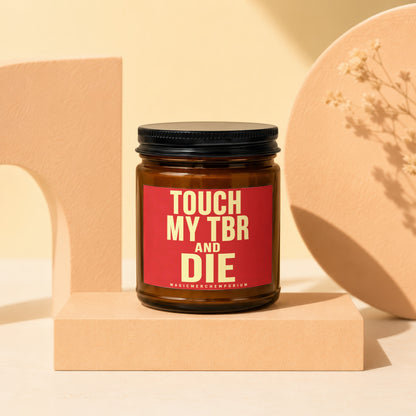 Brown candle with red label reading "Touch My TBR and Die".