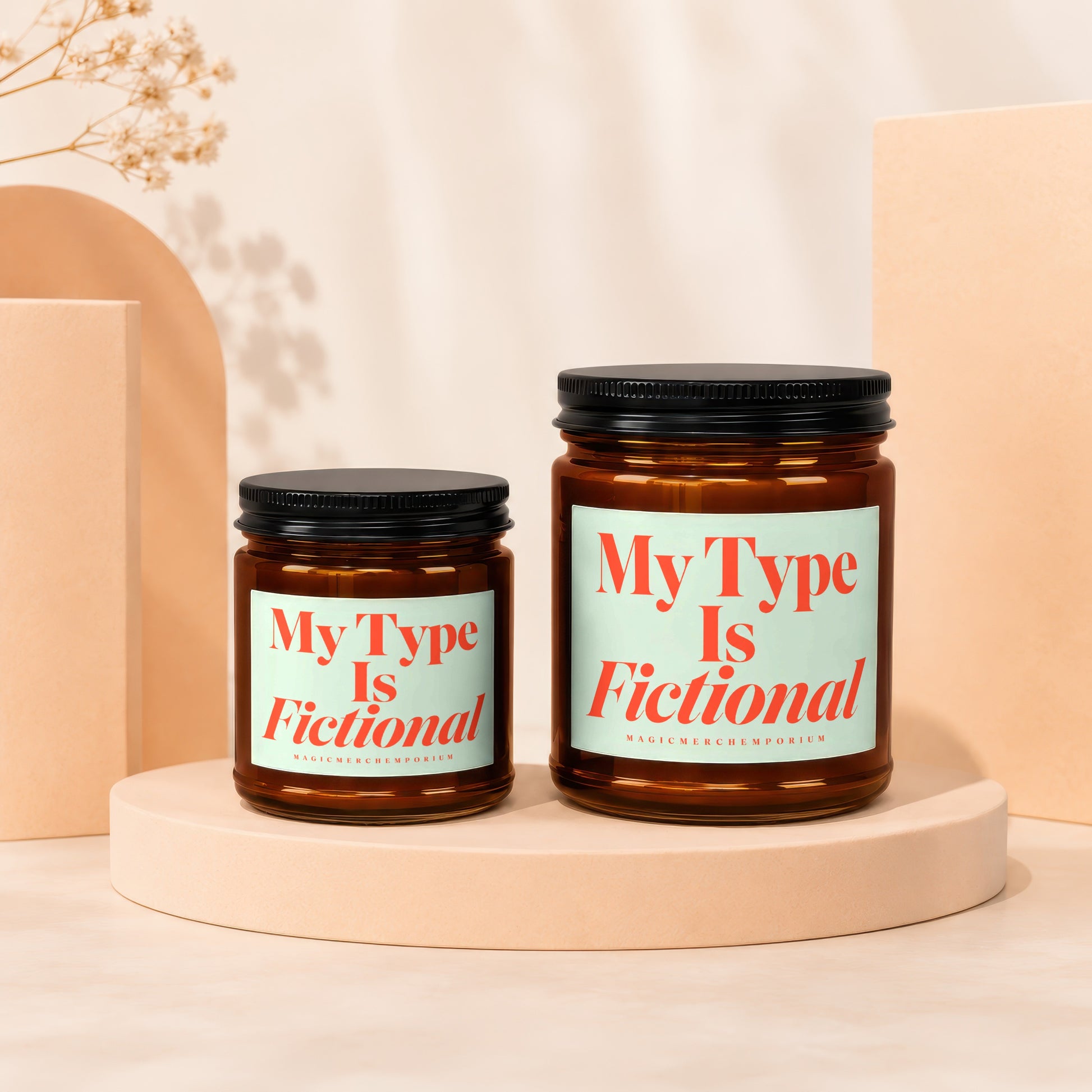 Two amber glass candles with black lids, one larger, both labeled "My Type Is Fictional".
