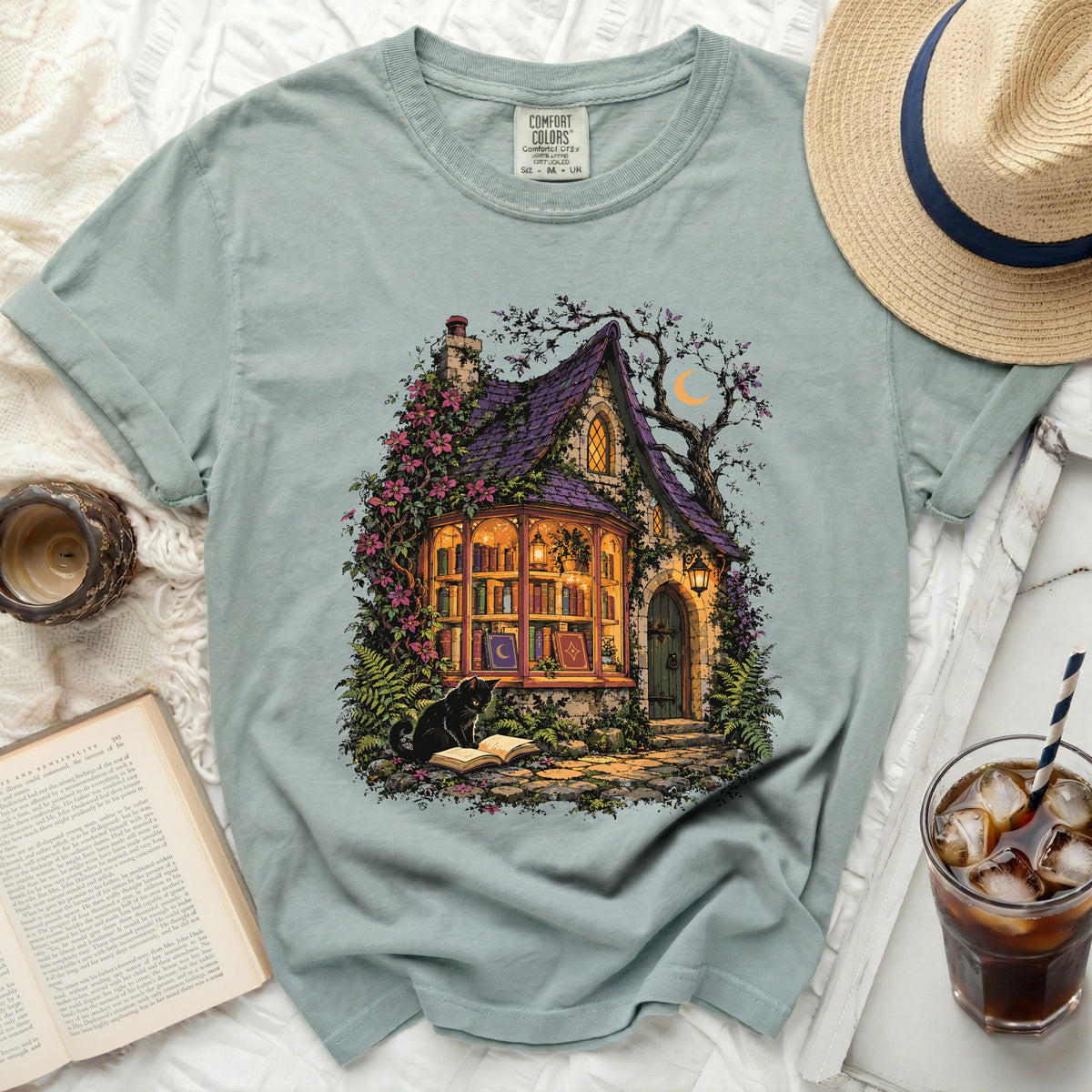 T-shirt with mystical cottage, cat reading a book, and a crescent moon.