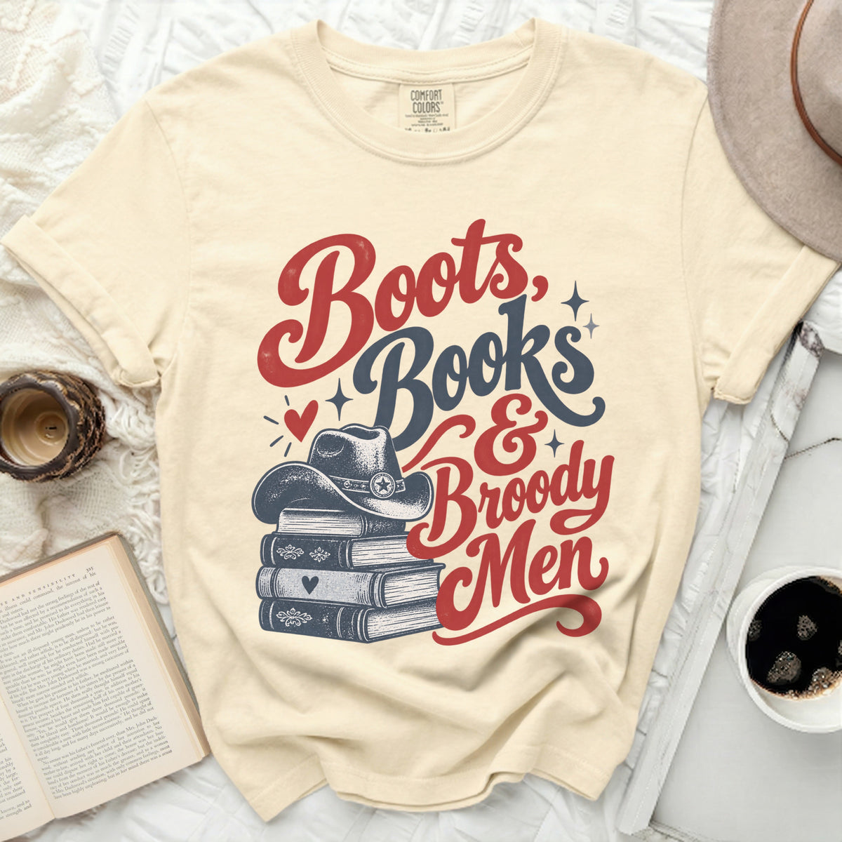 Boots, Books & Broody Men graphic on a cream t-shirt.