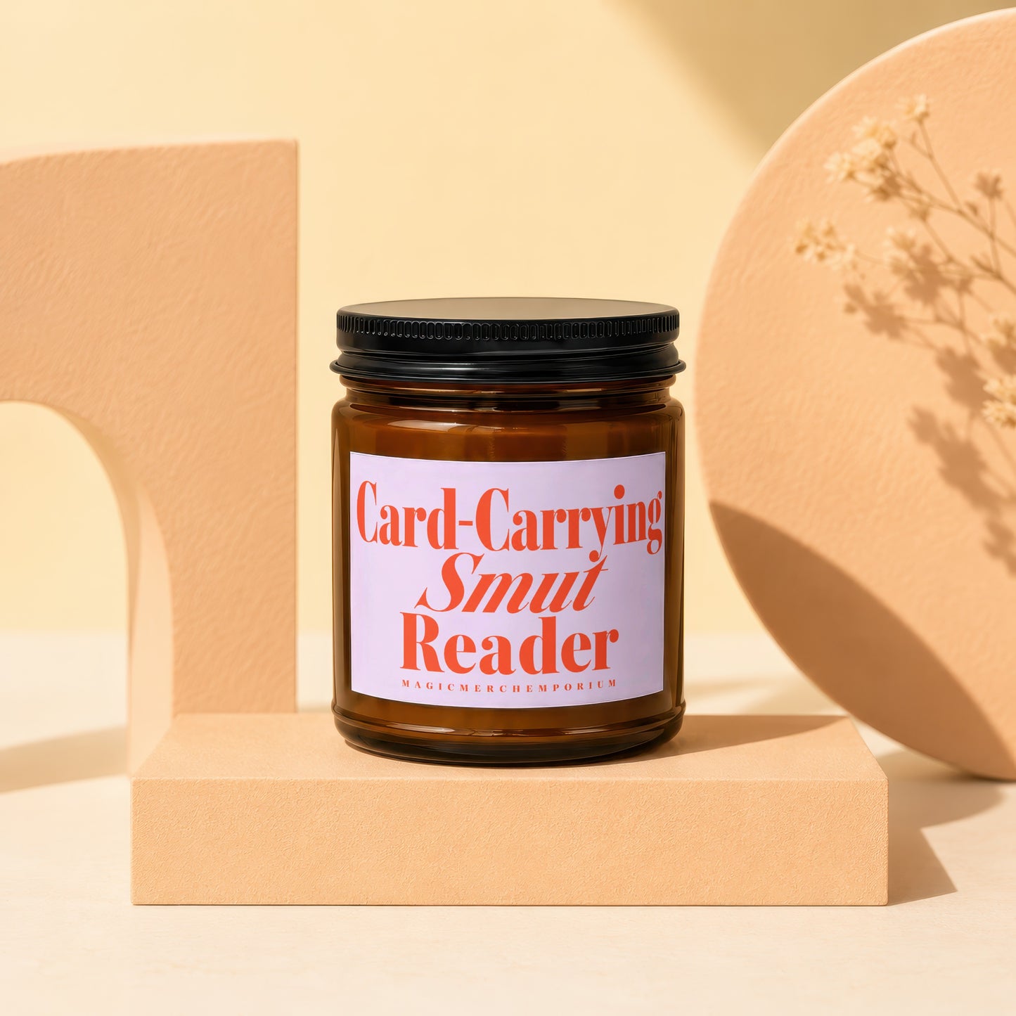 Brown glass candle with "Card-Carrying Smut Reader" label on display stand.