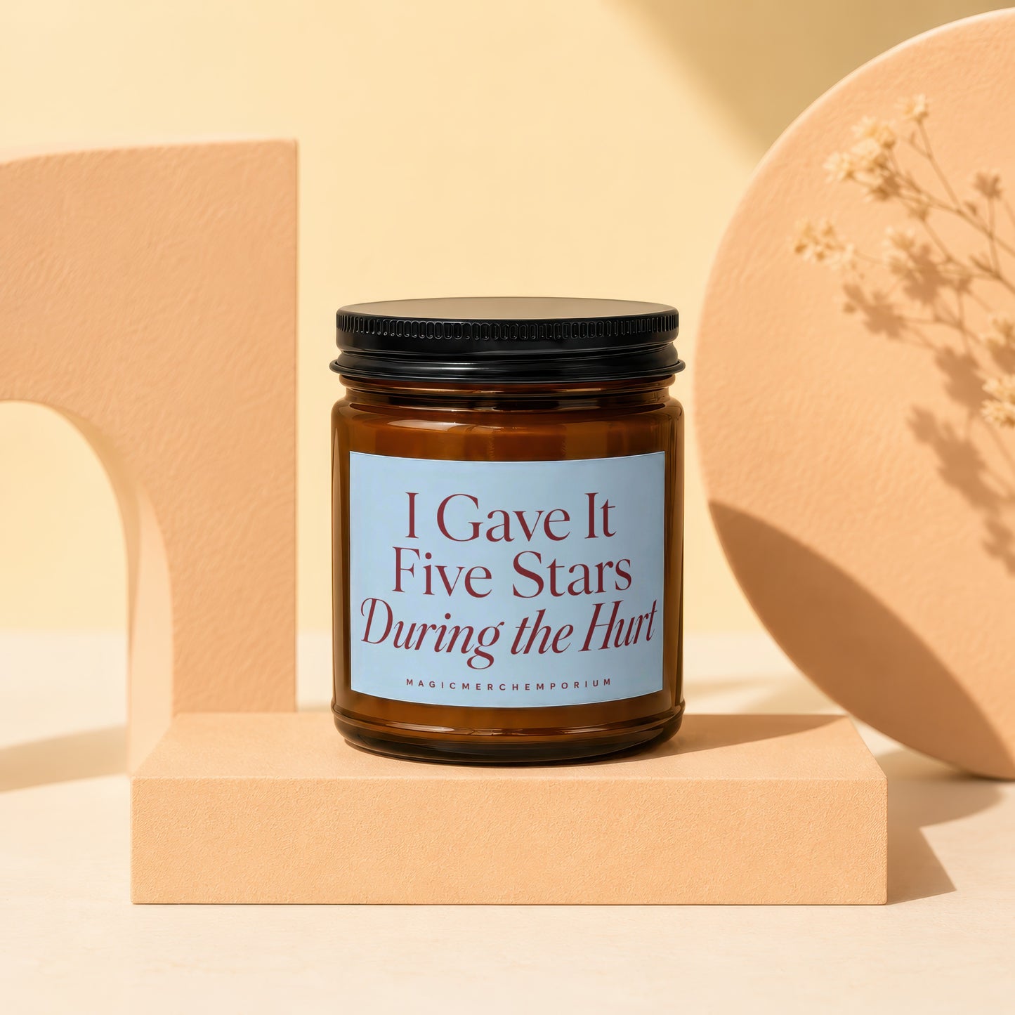 Brown glass candle with blue label reading "I Gave It Five Stars During the Hurt."