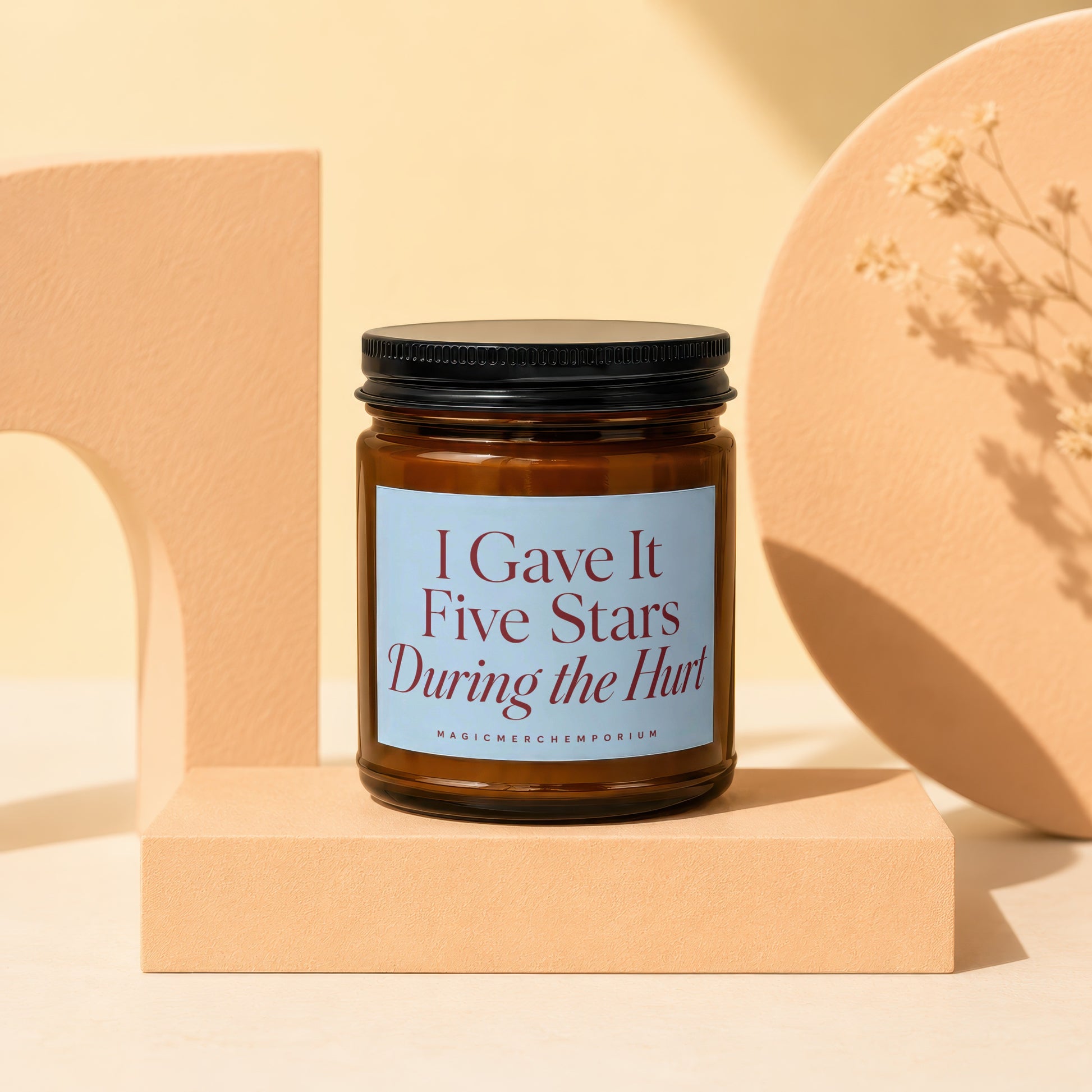 Brown glass candle with blue label reading "I Gave It Five Stars During the Hurt."