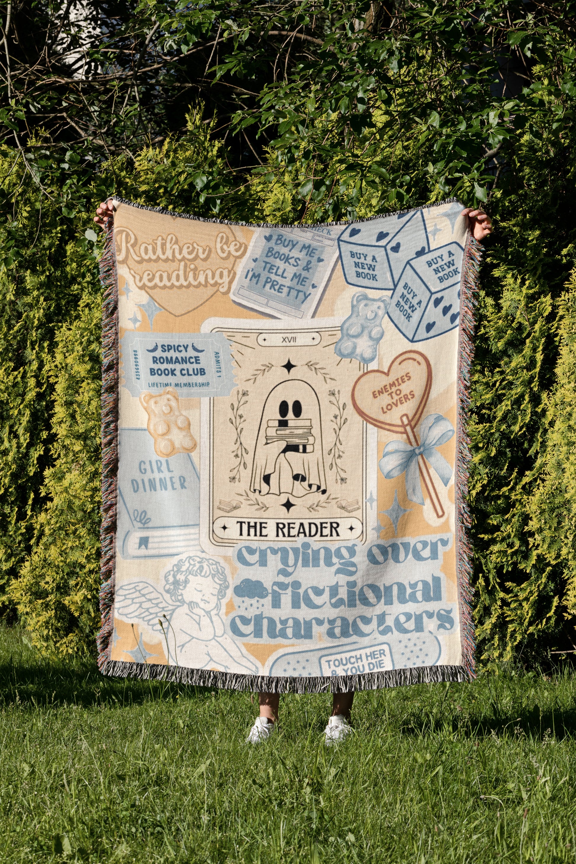 a person holding up a blanket with various text and illustrations related to reading and storytelling.