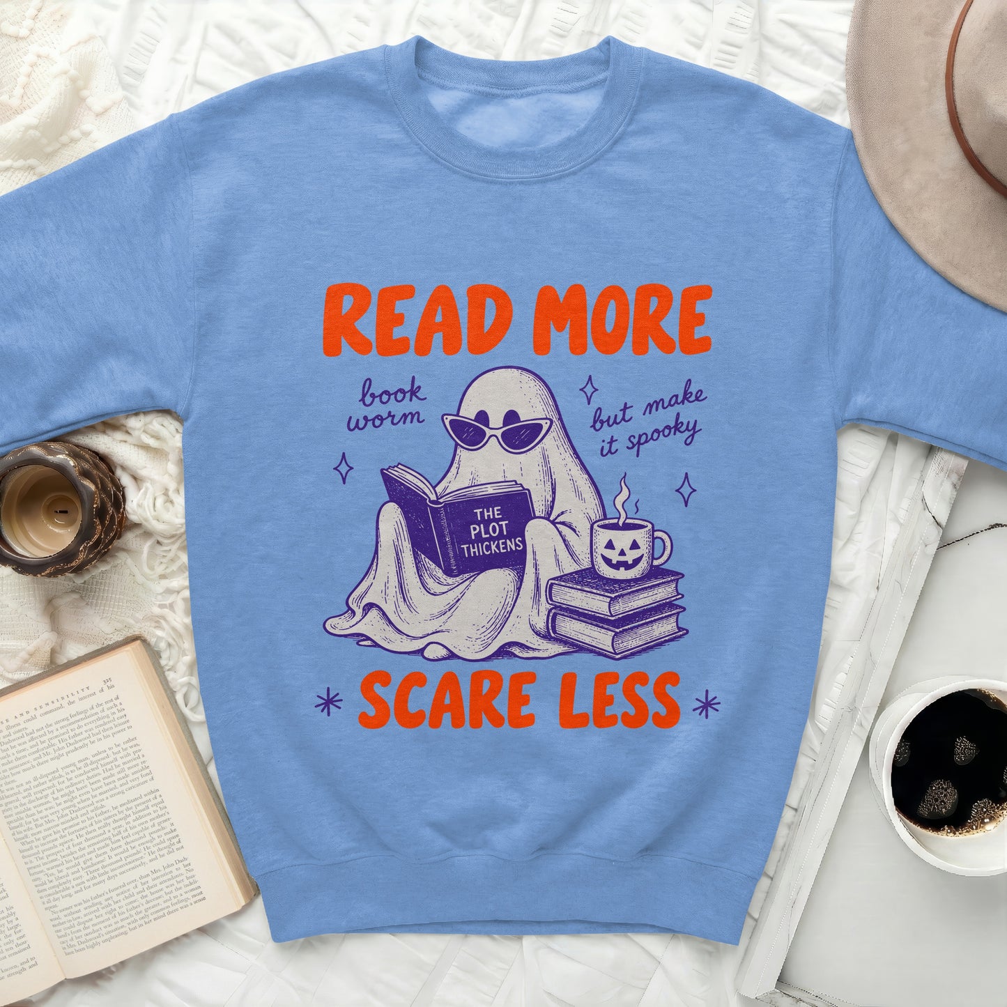 Ghost reading a book graphic on blue sweatshirt: Read More, book worm, but make it spooky, Scare Less.