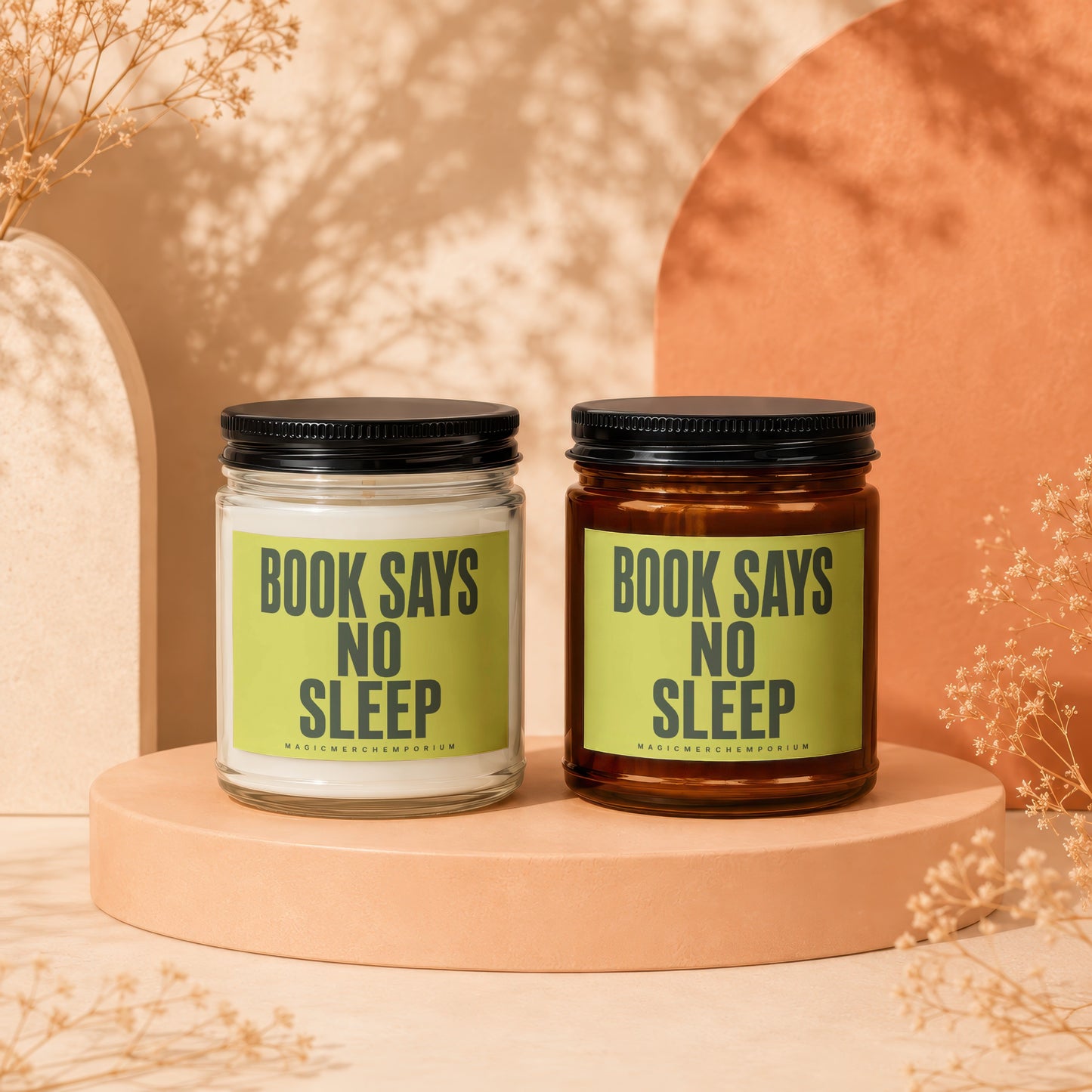 Two candles with black lids on a peach colored stand, text reads "BOOK SAYS NO SLEEP"