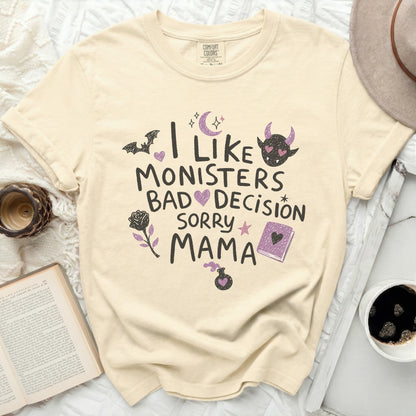 Cream t-shirt with "I Like Monsters But That's A Bad Decision Sorry Mama" graphic.