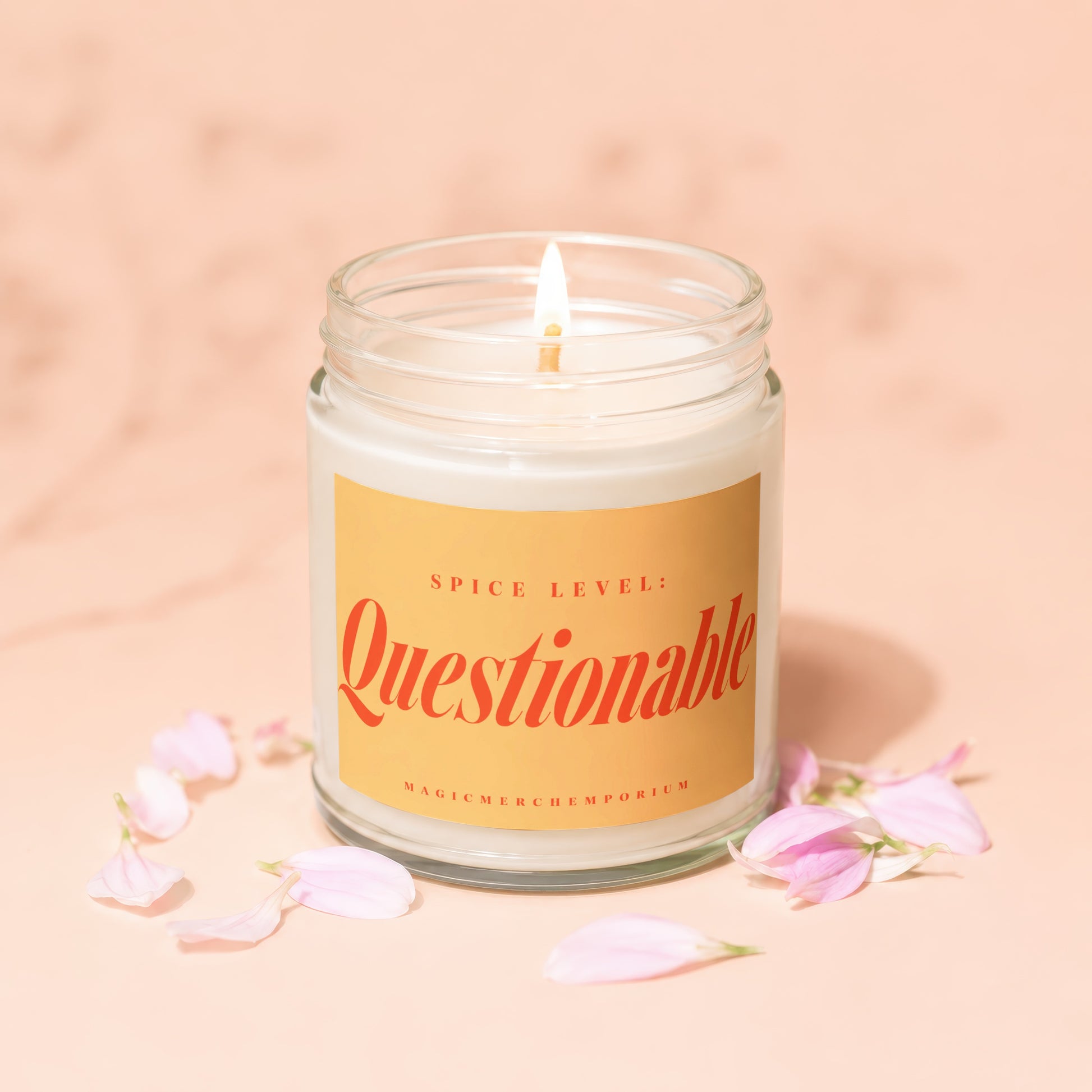 Glass jar candle with lit wick and yellow label reading "Spice Level: Questionable"