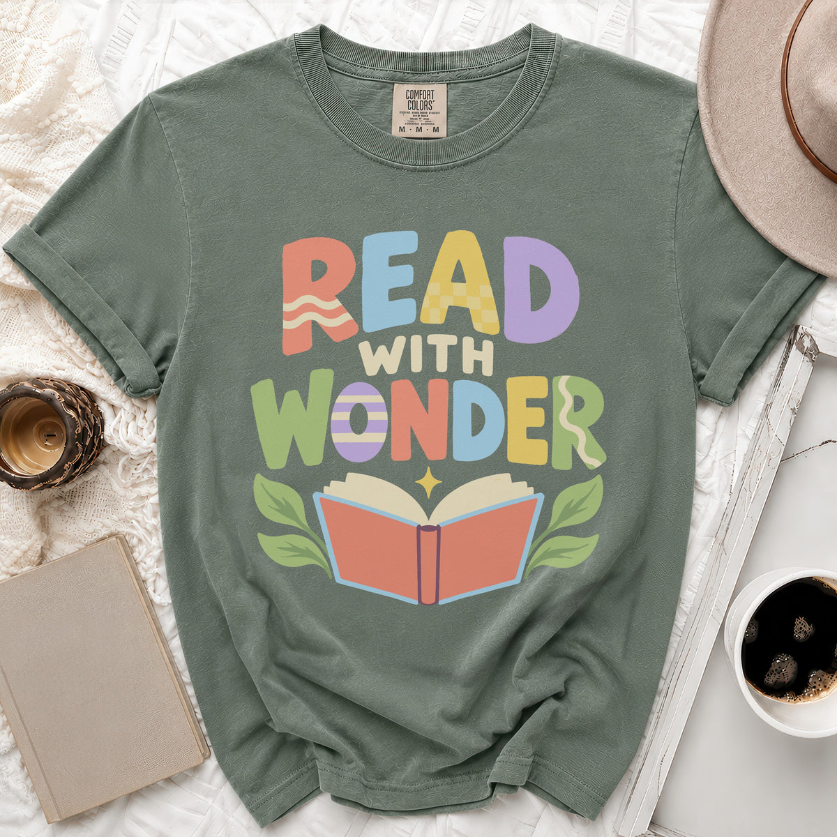 Green t-shirt with "READ WITH WONDER" text and open book graphic.