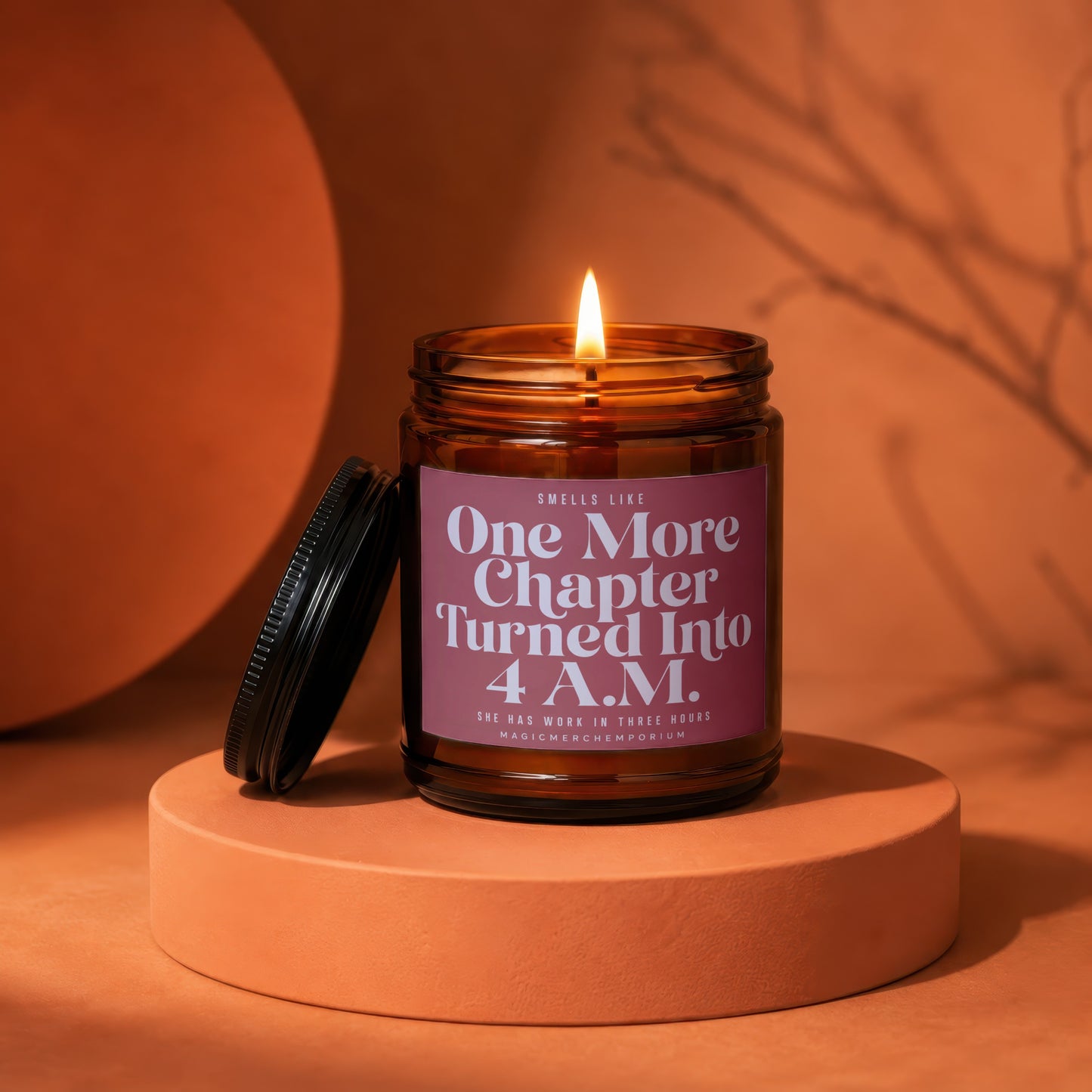 Burning candle in amber jar with "One More Chapter Turned Into 4 A.M." label.