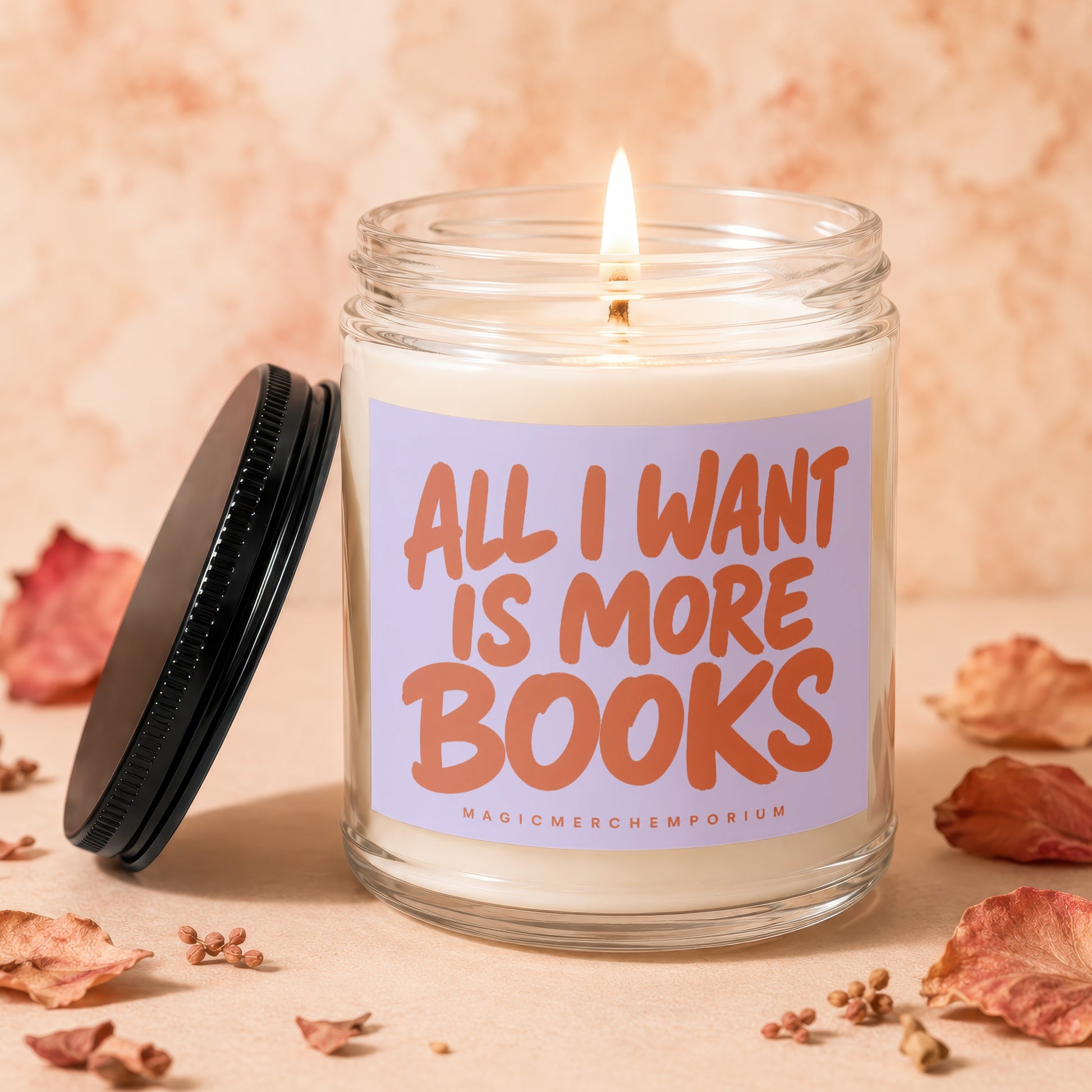 Glass candle with lid and flame, reading "All I Want Is More Books."