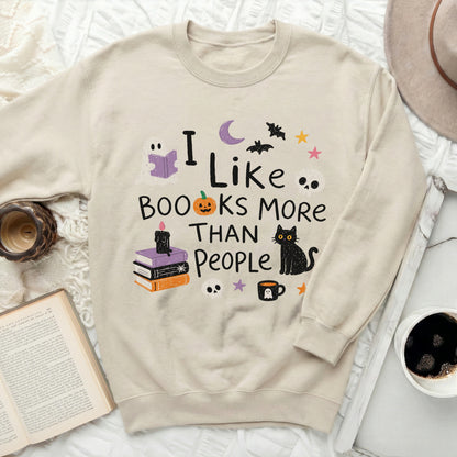 Cream sweatshirt with "I Like Books More Than People" and Halloween graphics.