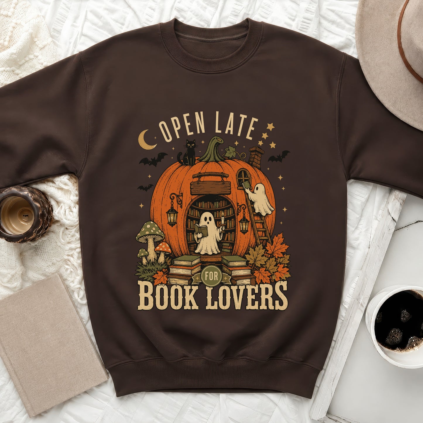 Brown sweatshirt with "Open Late For Book Lovers" graphic of a pumpkin library and ghosts.