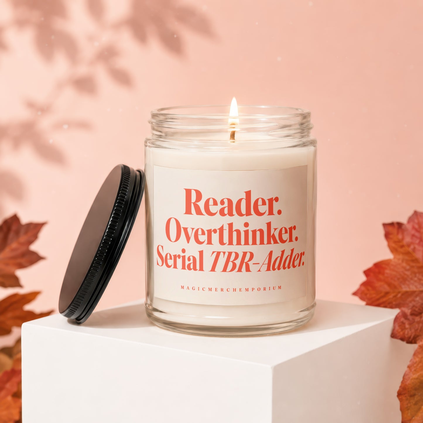 Candle with "Reader. Overthinker. Serial TBR-Adder." text, lit flame, and lid off.