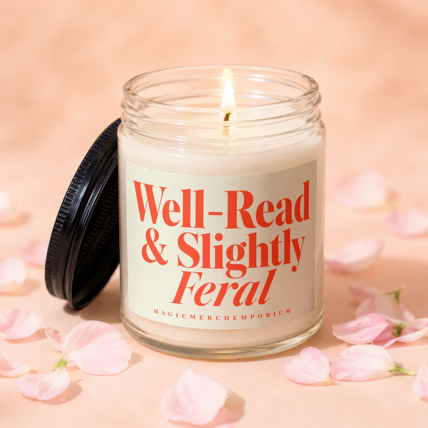 Lit candle in glass jar with "Well-Read & Slightly Feral" text, surrounded by petals.