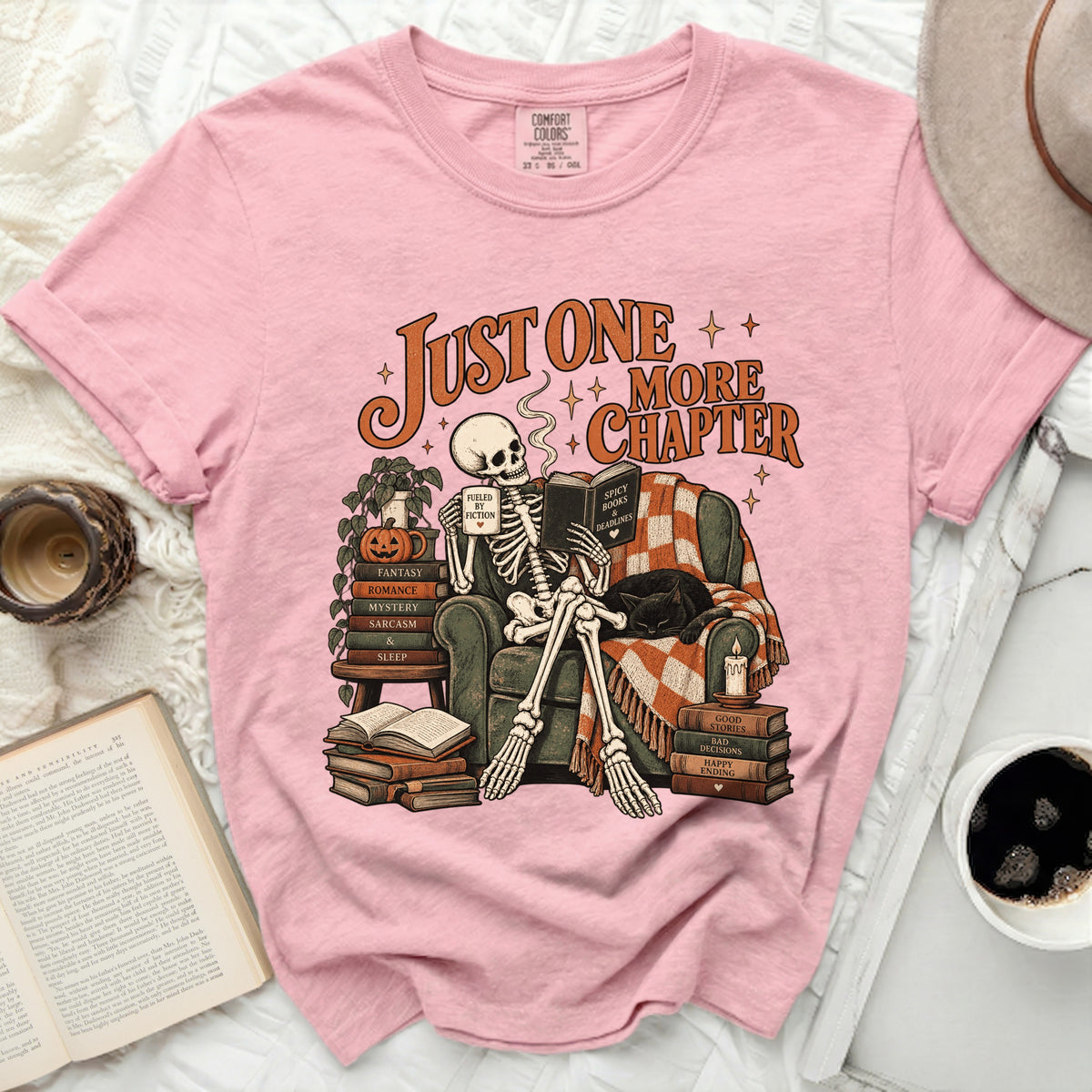 Pink t-shirt with skeleton reading, "Just One More Chapter" text.