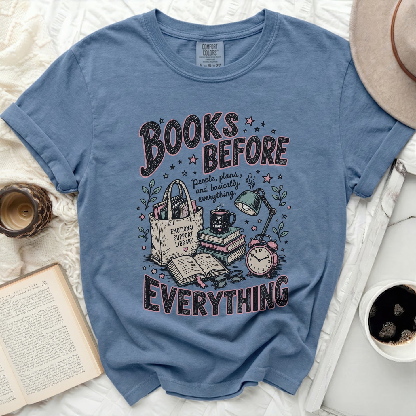 Blue t-shirt with "Books Before Everything" graphic, a tote bag, and books.