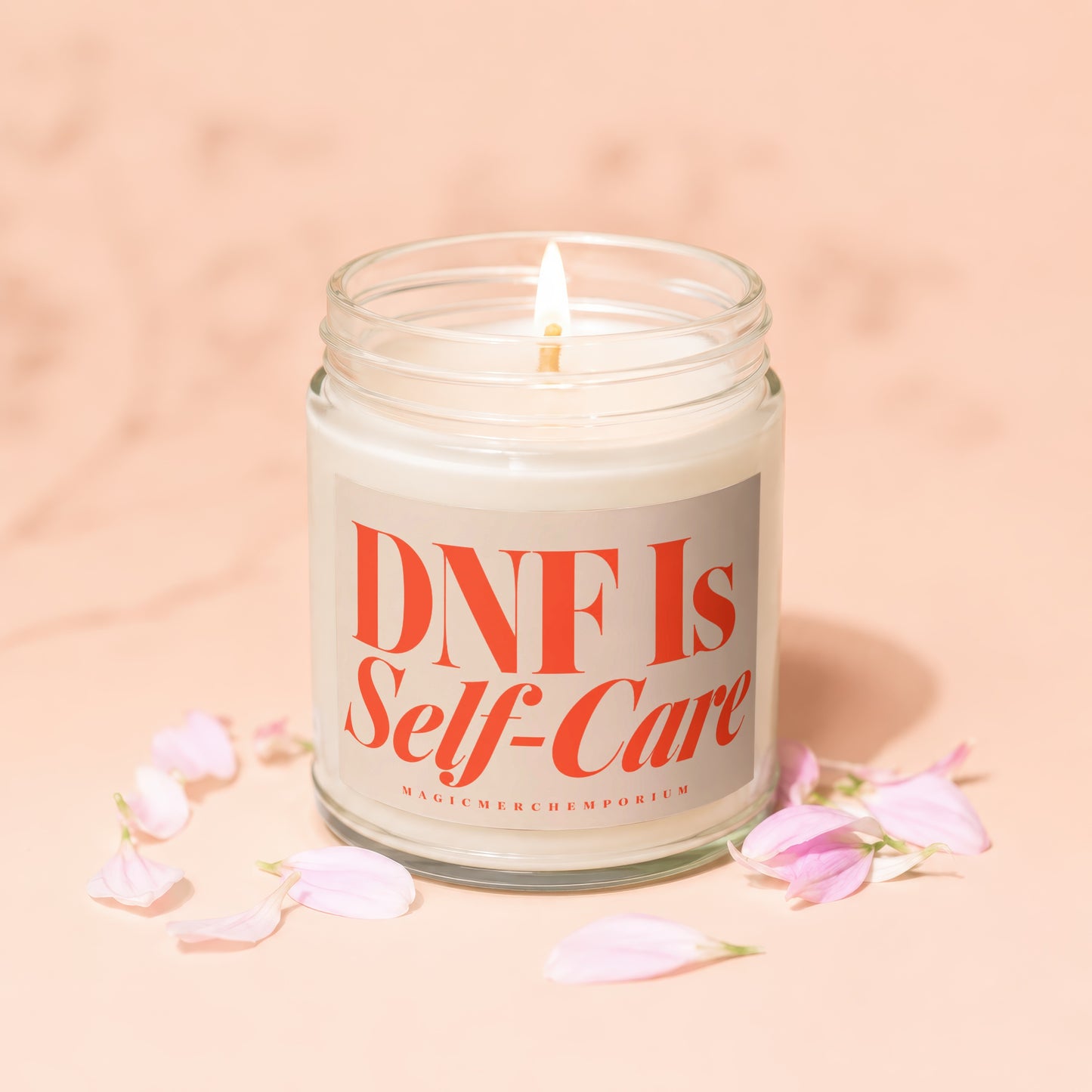 Jar candle with lit wick and "DNF Is Self-Care" text surrounded by pink petals.