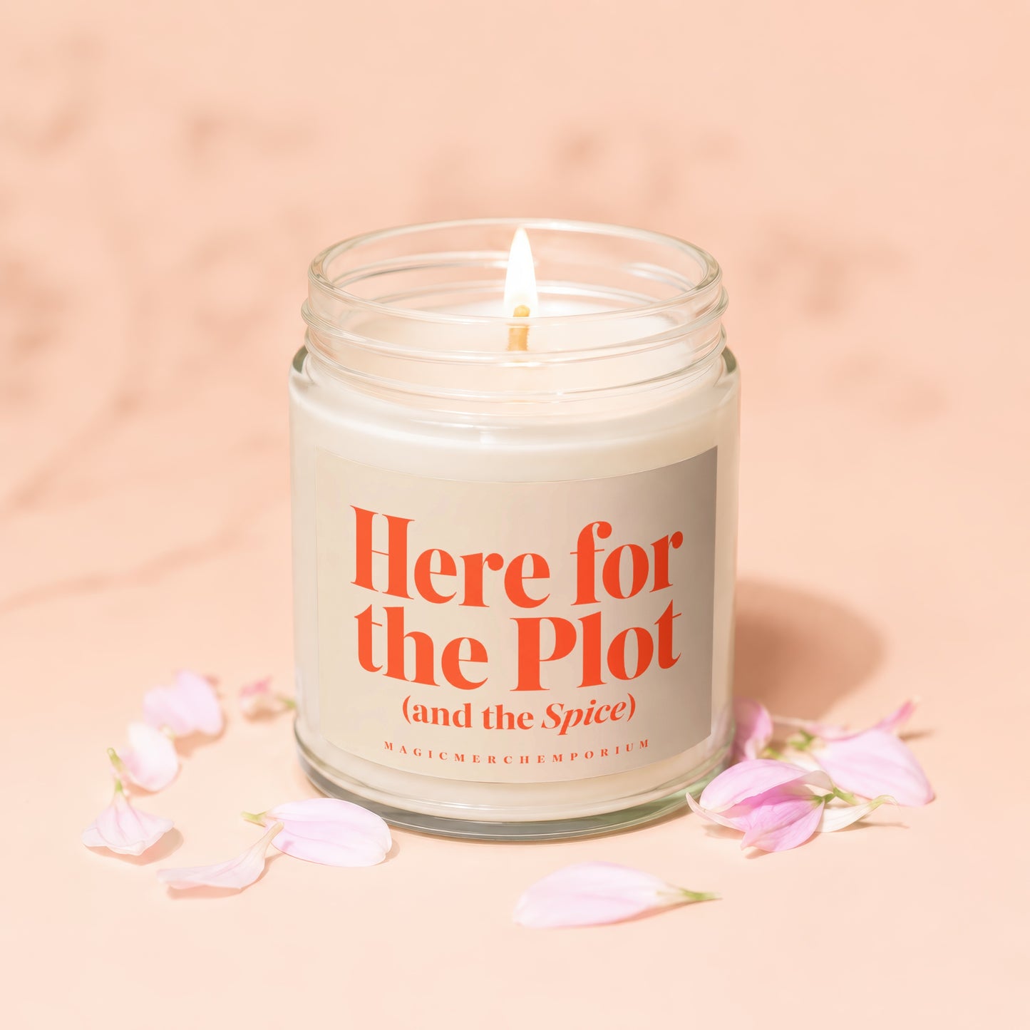 Glass jar candle with lit wick, "Here for the Plot (and the Spice)" text on label.