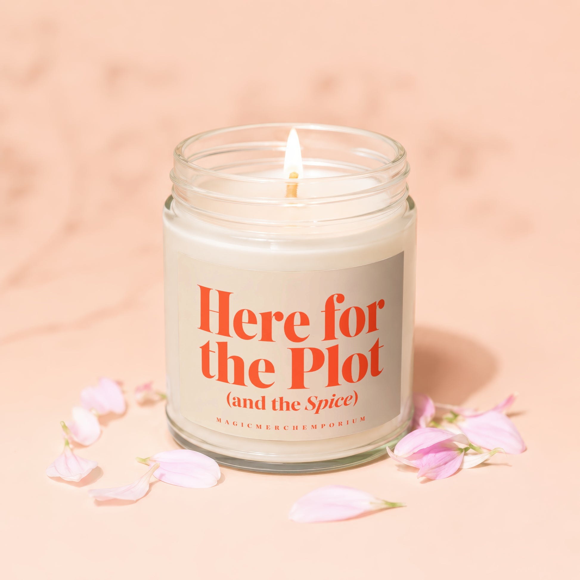 Glass jar candle with lit wick, "Here for the Plot (and the Spice)" text on label.
