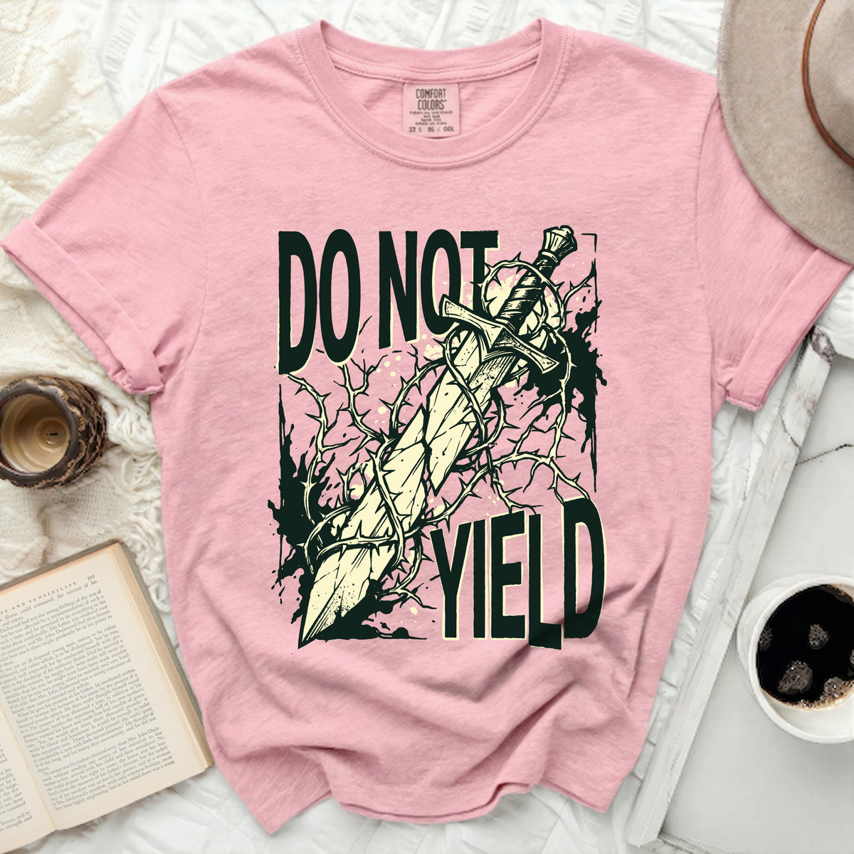 Pink t-shirt with a sword and thorns graphic that reads "DO NOT YIELD".