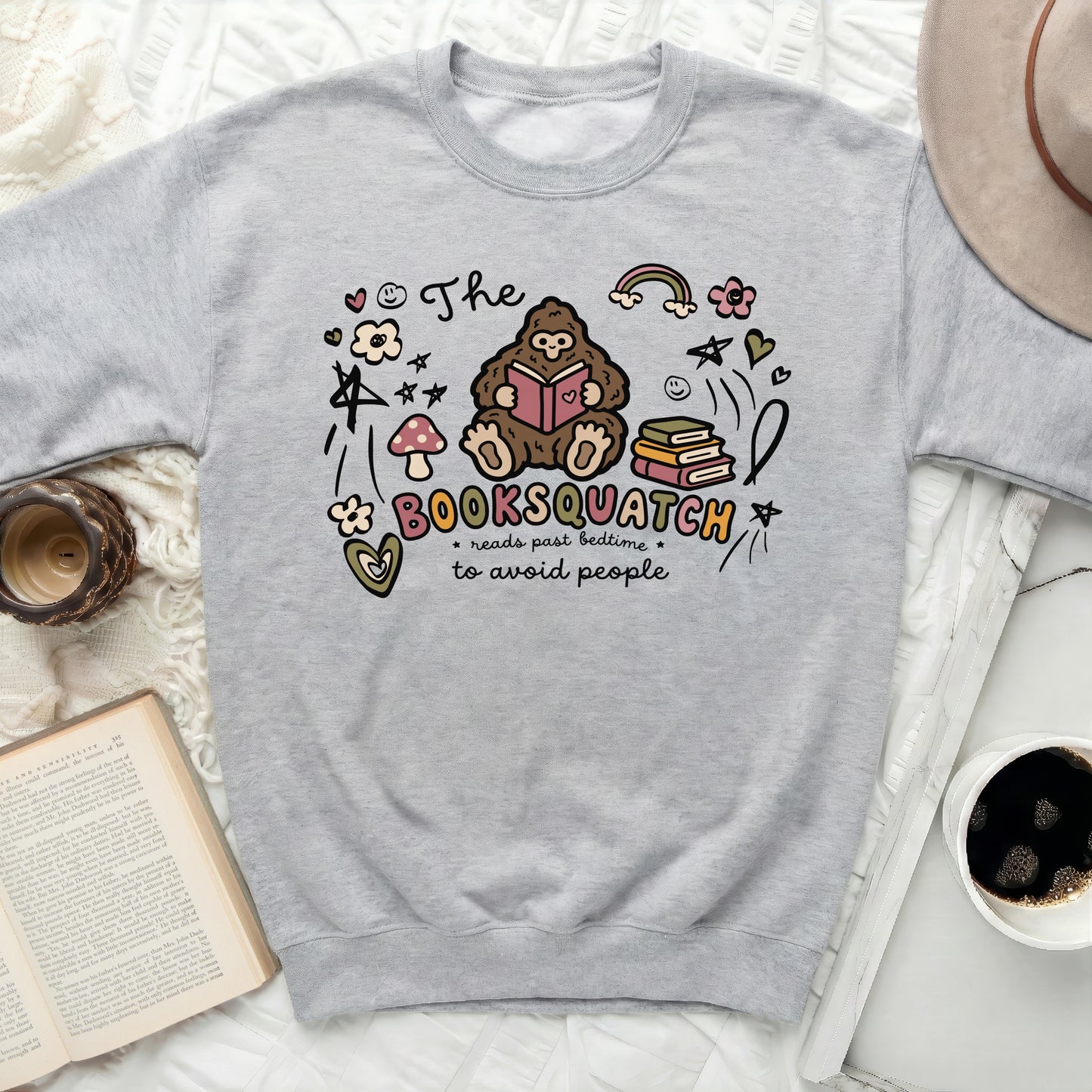 Grey sweatshirt with "The Booksquatch reads past bedtime to avoid people" graphic.