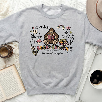 Grey sweatshirt with "The Booksquatch reads past bedtime to avoid people" graphic.