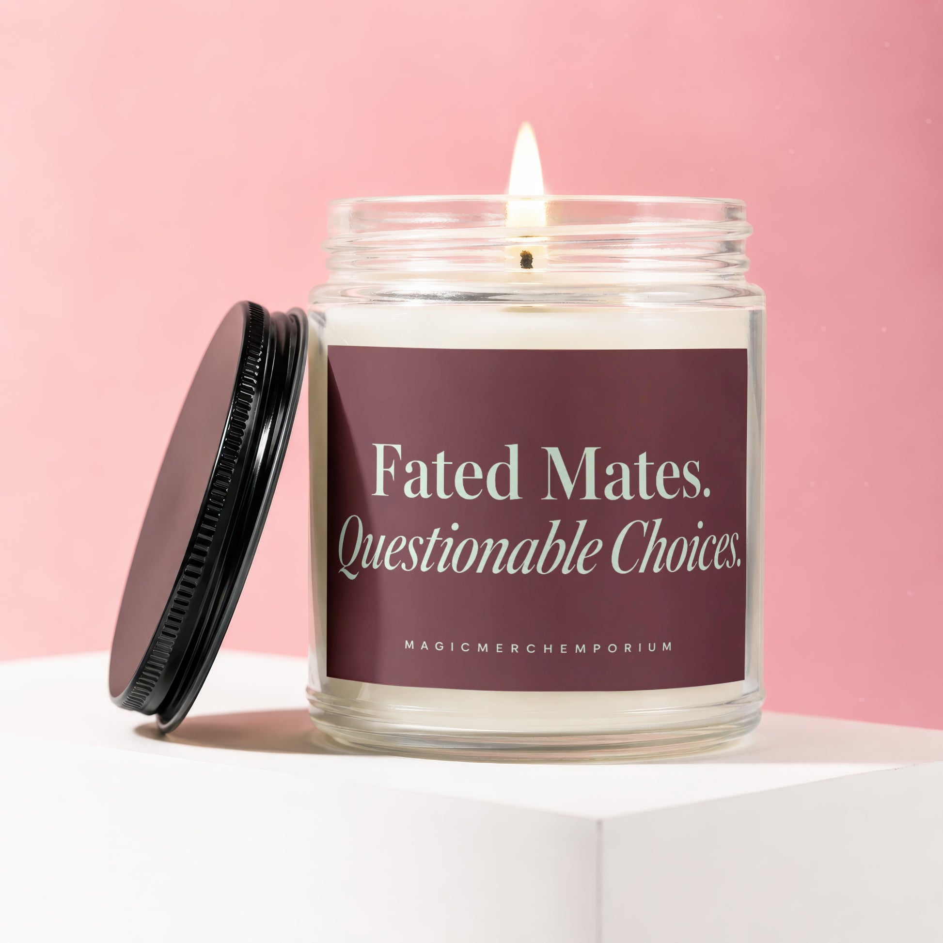 Lit candle in glass jar with black lid, reading "Fated Mates. Questionable Choices. MAGIC MERCHEMPORIUM".