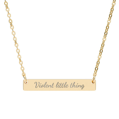Gold bar necklace with "Violent little thing" engraved in cursive.