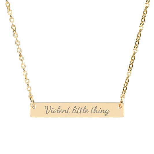 Gold bar necklace with "Violent little thing" engraved in cursive.