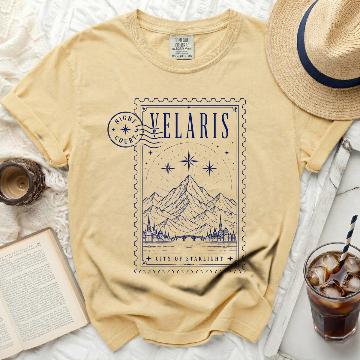 Yellow t-shirt with a blue stamp design featuring mountains and the text "Velaris City of Starlight".